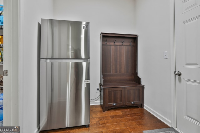 interior space featuring dark brown cabinets, stainless steel fridge, and dark wood-type flooring