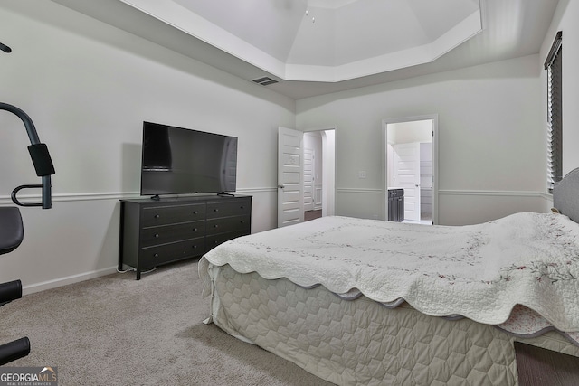 bedroom featuring a tray ceiling and light carpet