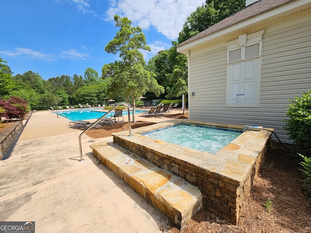 view of swimming pool with an in ground hot tub and a patio area