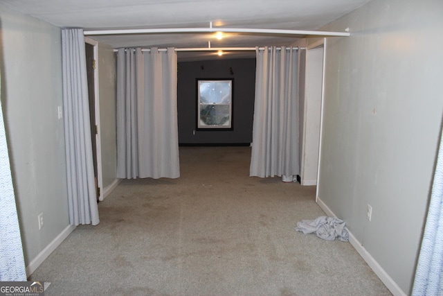 hallway featuring light colored carpet