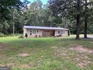 single story home featuring a front lawn