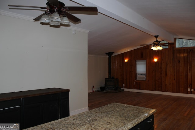 living room featuring a wood stove, crown molding, wooden walls, and dark wood-type flooring