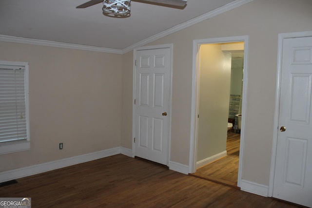 unfurnished bedroom featuring crown molding, dark hardwood / wood-style flooring, and vaulted ceiling