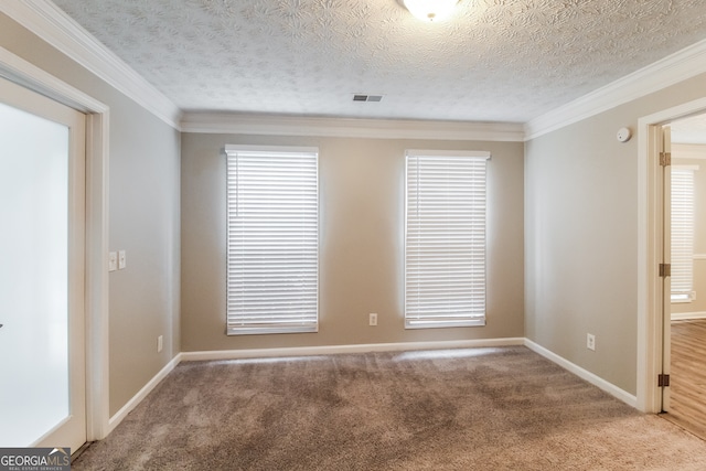 empty room with carpet floors, a textured ceiling, and ornamental molding