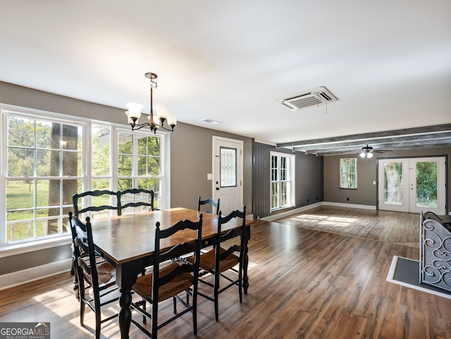 dining space with ceiling fan with notable chandelier, french doors, and dark hardwood / wood-style floors