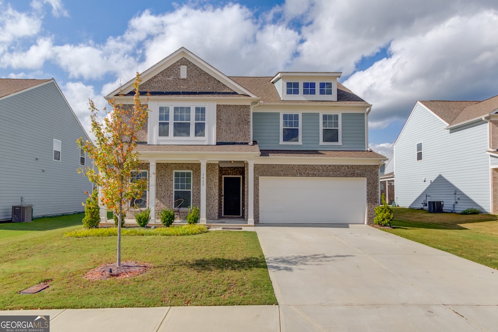 craftsman house with a front lawn, central AC unit, and a garage