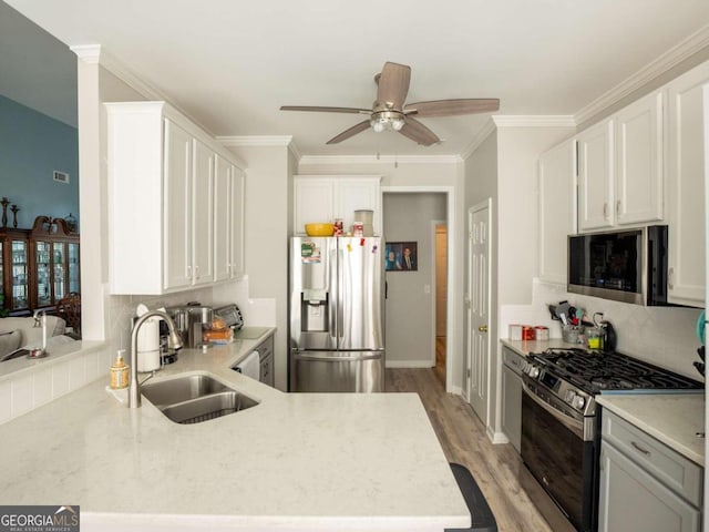 kitchen with decorative backsplash, sink, white cabinets, and appliances with stainless steel finishes