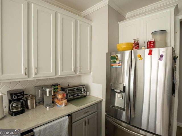 kitchen with white cabinetry, decorative backsplash, stainless steel fridge, and ornamental molding