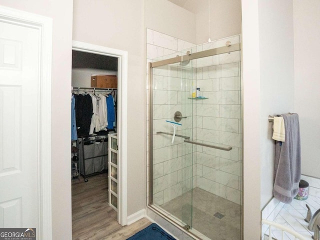 bathroom with hardwood / wood-style floors and a shower with shower door