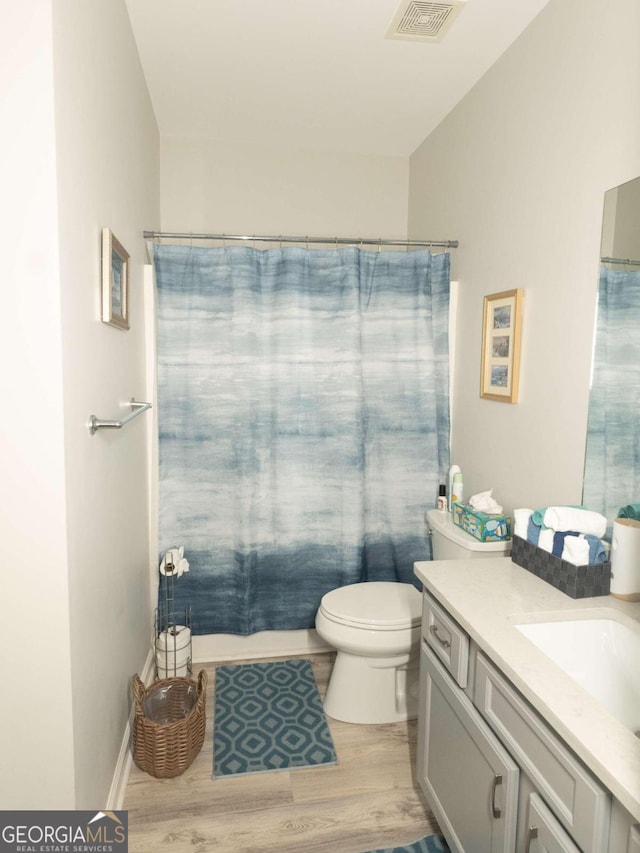 full bathroom with hardwood / wood-style flooring, vanity, toilet, and shower / bath combo