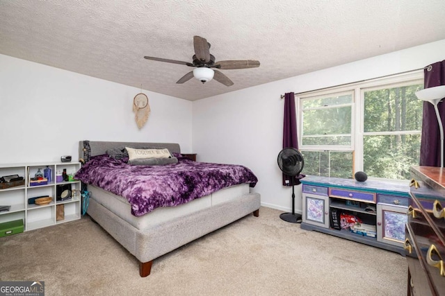 bedroom featuring carpet, ceiling fan, and a textured ceiling