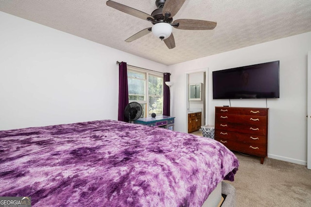 carpeted bedroom with ceiling fan, a textured ceiling, and connected bathroom