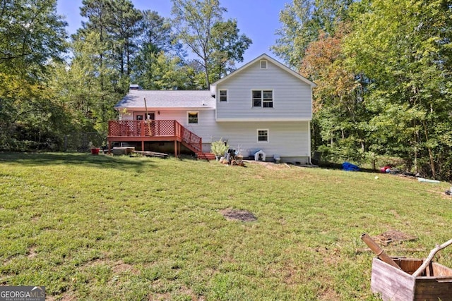 rear view of house with a lawn and a deck