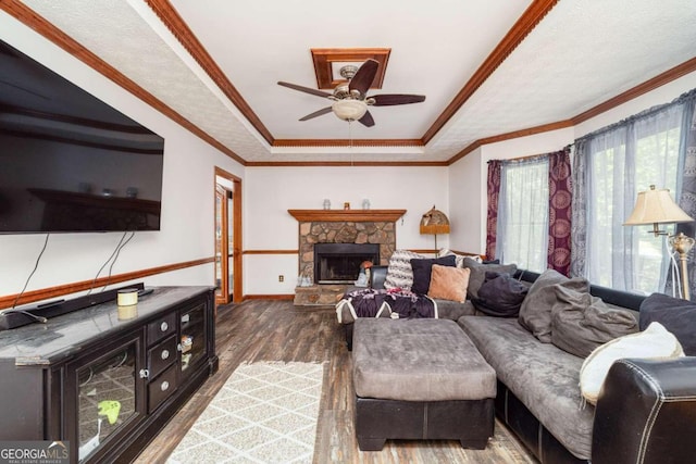 living room featuring wood-type flooring, a stone fireplace, and ornamental molding