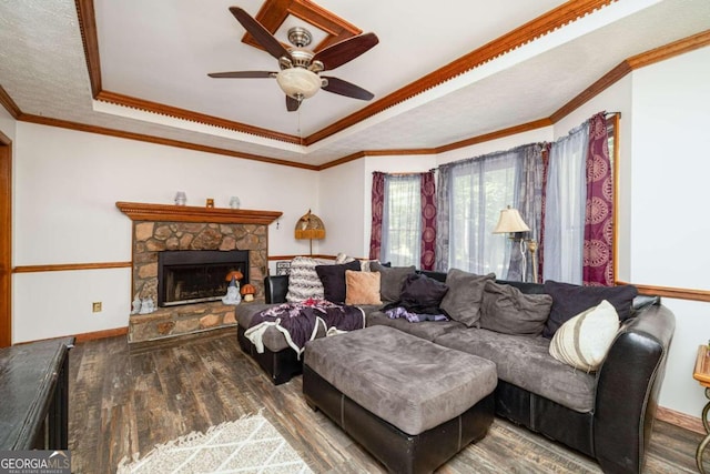 living room featuring crown molding, a fireplace, ceiling fan, and hardwood / wood-style flooring