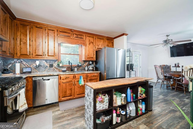 kitchen featuring backsplash, dark hardwood / wood-style flooring, stainless steel appliances, ceiling fan, and sink