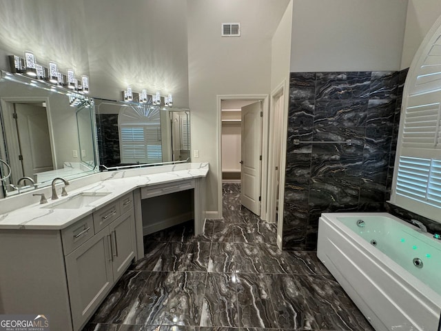 bathroom featuring a tub, tile walls, and vanity