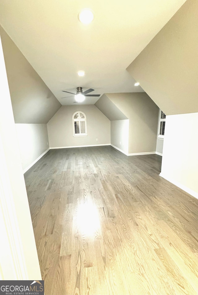 additional living space with lofted ceiling, hardwood / wood-style flooring, and ceiling fan