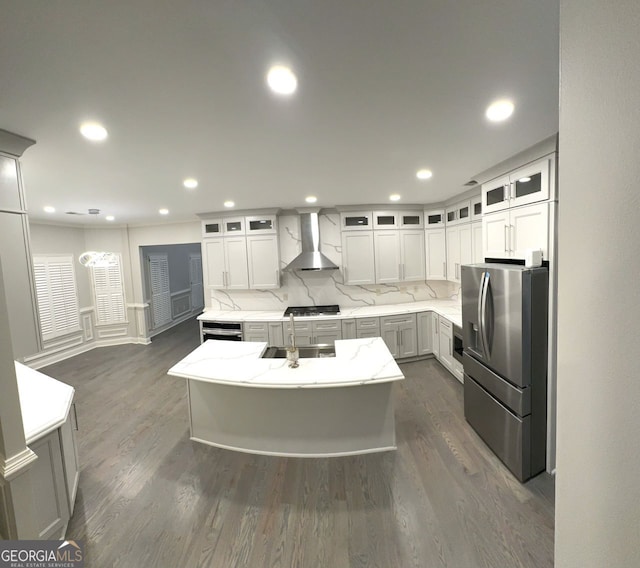 kitchen with dark hardwood / wood-style floors, wall chimney exhaust hood, a center island, and stainless steel appliances