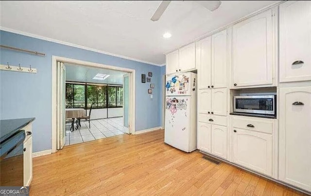 kitchen featuring white cabinetry, white refrigerator, black dishwasher, light wood-type flooring, and ornamental molding