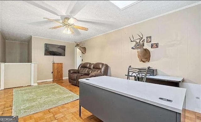 living room with ceiling fan, a skylight, ornamental molding, a textured ceiling, and parquet flooring