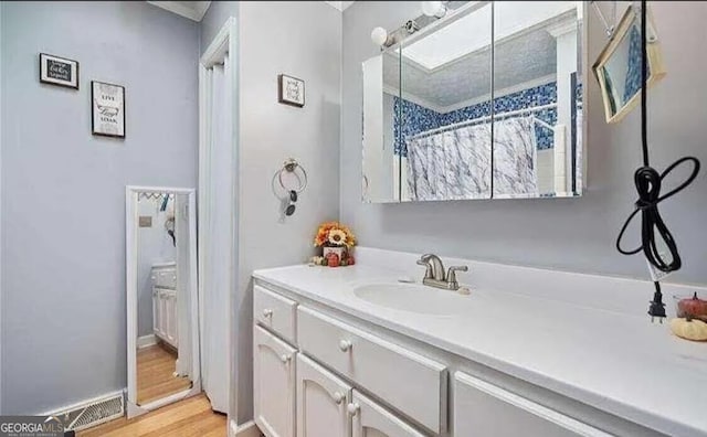 bathroom featuring vanity, curtained shower, and hardwood / wood-style flooring