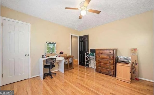 office with a textured ceiling, ceiling fan, and light hardwood / wood-style flooring