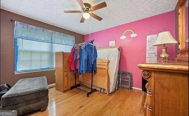 bedroom featuring a textured ceiling, hardwood / wood-style floors, and ceiling fan