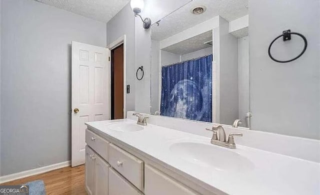 bathroom with vanity, hardwood / wood-style floors, and a textured ceiling