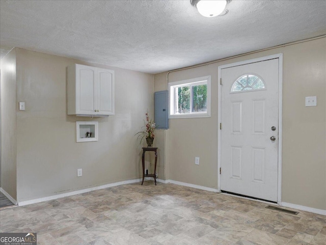 foyer with a textured ceiling and electric panel