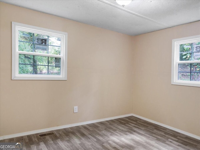 empty room with a textured ceiling and hardwood / wood-style floors