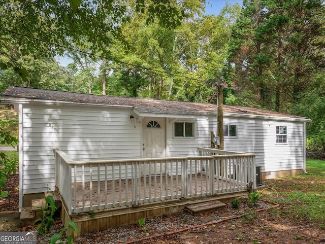 rear view of property featuring a wooden deck