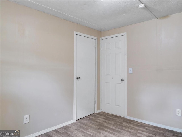 unfurnished bedroom with a textured ceiling and hardwood / wood-style flooring