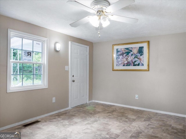 spare room with a textured ceiling and ceiling fan