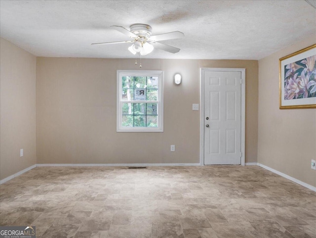 unfurnished room with a textured ceiling and ceiling fan