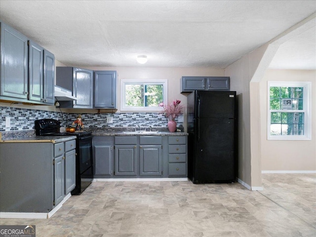 kitchen with a textured ceiling, sink, range hood, decorative backsplash, and black appliances