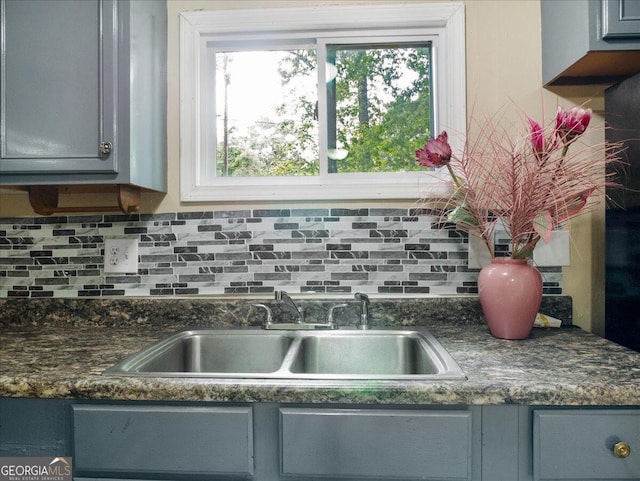 kitchen featuring decorative backsplash, gray cabinetry, and sink