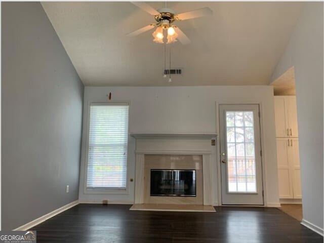 unfurnished living room featuring vaulted ceiling, ceiling fan, and dark wood-type flooring