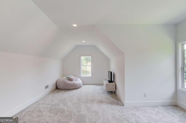 unfurnished room featuring vaulted ceiling and light carpet