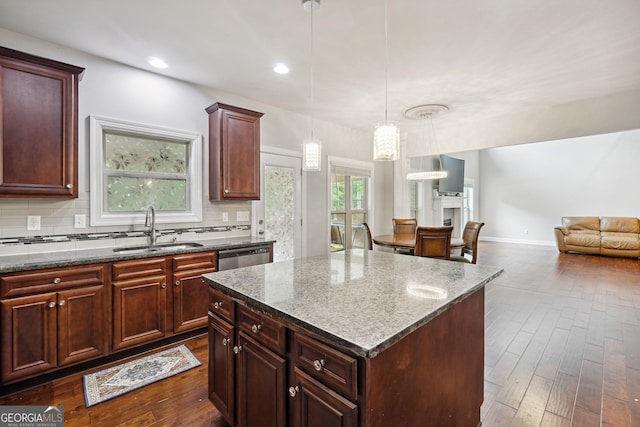 kitchen with a kitchen island, sink, dark wood-type flooring, and a wealth of natural light