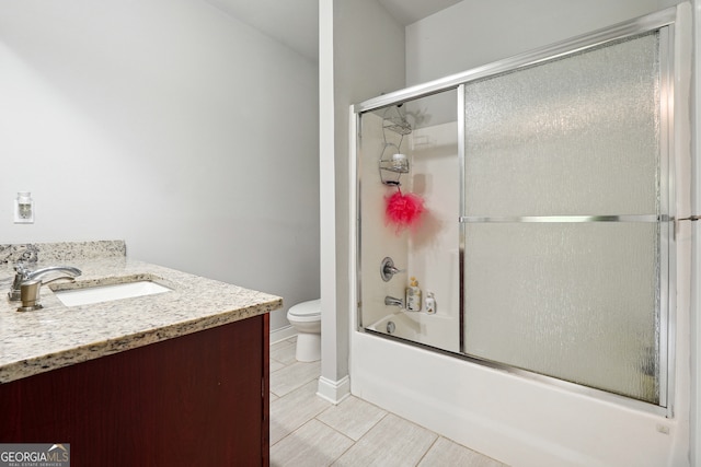 full bathroom featuring tile patterned flooring, enclosed tub / shower combo, vanity, and toilet