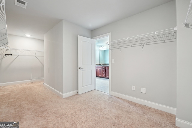 walk in closet featuring light carpet