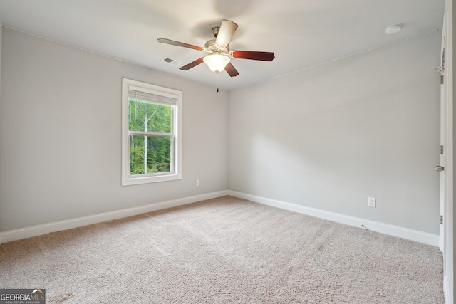 carpeted spare room featuring ceiling fan