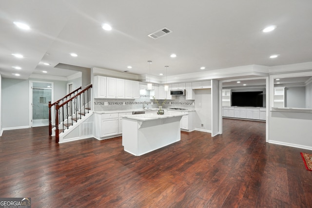 kitchen featuring white cabinets, decorative light fixtures, backsplash, a center island, and dark hardwood / wood-style flooring