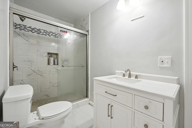 bathroom with vanity, toilet, and a shower with door