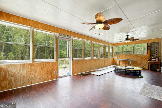 unfurnished sunroom featuring a healthy amount of sunlight and ceiling fan