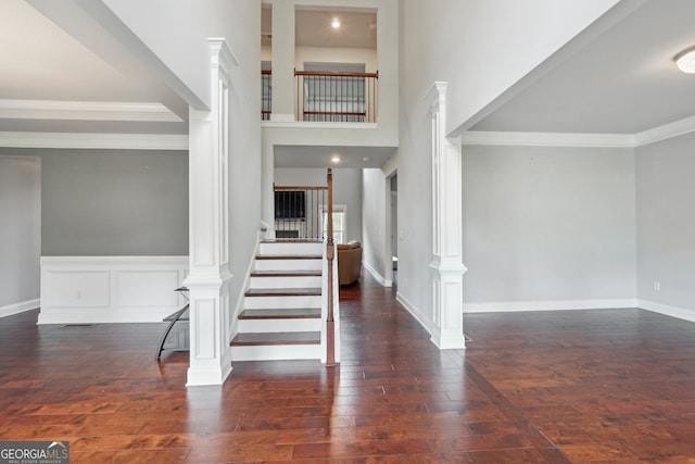 entryway with crown molding, dark hardwood / wood-style flooring, and a high ceiling