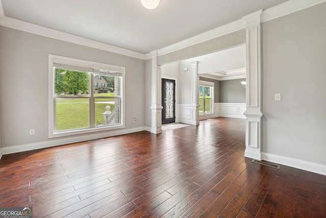 unfurnished room with ornamental molding, dark wood-type flooring, and decorative columns