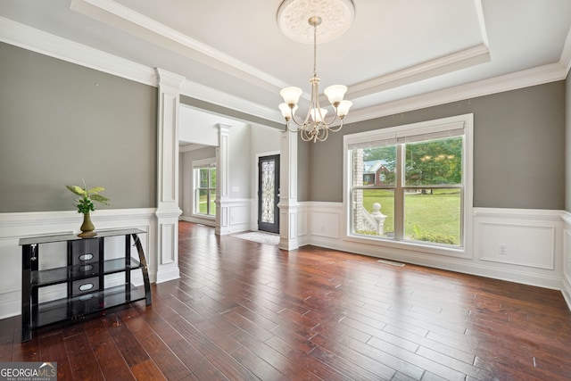 interior space featuring a wealth of natural light, decorative columns, and dark hardwood / wood-style floors