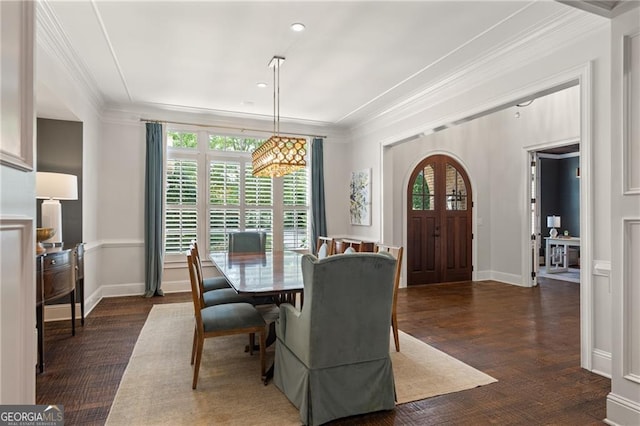 dining area with a wealth of natural light, crown molding, and dark hardwood / wood-style floors